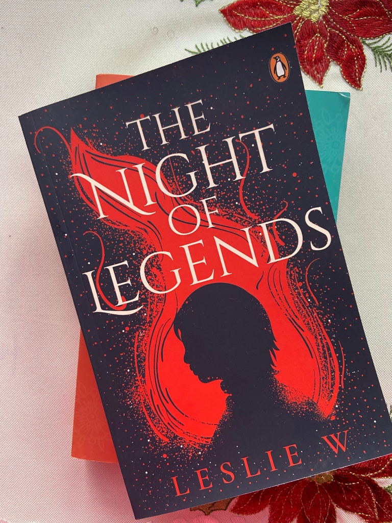 The Night of Legends by Leslie W is stacked on a few books.
